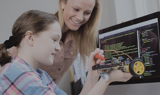 teacher assisting a student in building a robot car