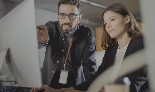 man and woman working together on a computer