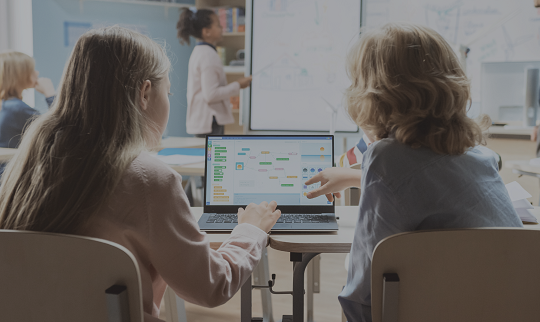 a teacher and student working together on a computer