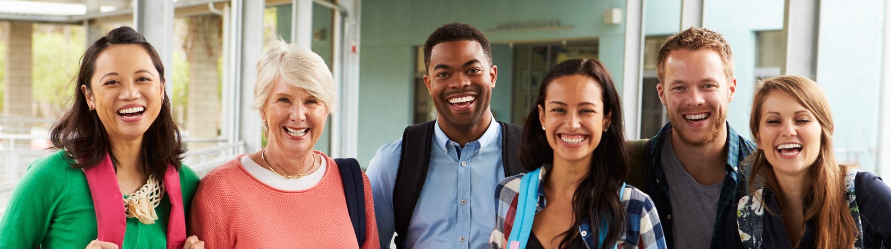 A group of cheerful teachers hanging out in school corridor