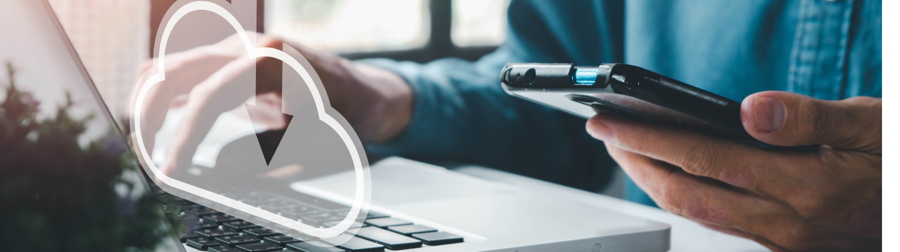 hands typing on a laptop with a holographic cloud icon coming from the screen