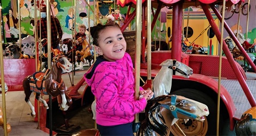 child riding a carrousel