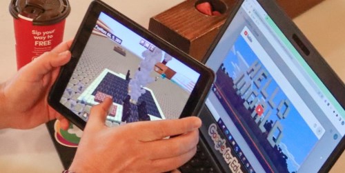 person playing minecraft on a tablet